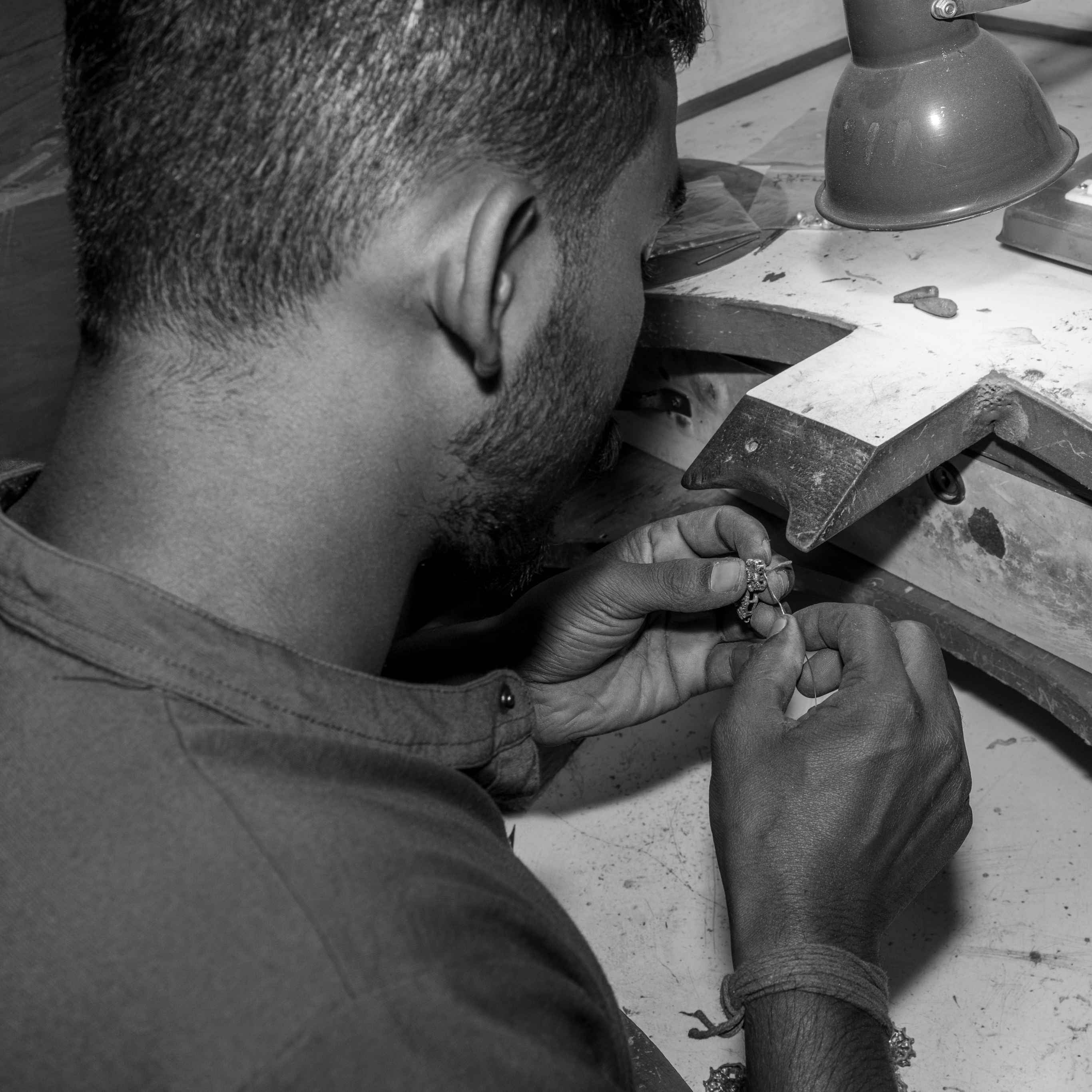 Miraura Workshop,person working on a small jewellery with tools at a workbench.
