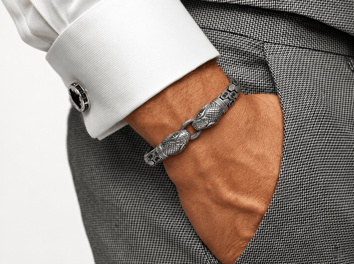 A close-up of a textured silver chain bracelet with a detailed snake head clasp, worn on a man's wrist. 925 Sterling Silver Double Snake Head Bracelet by Miraura Jewels
