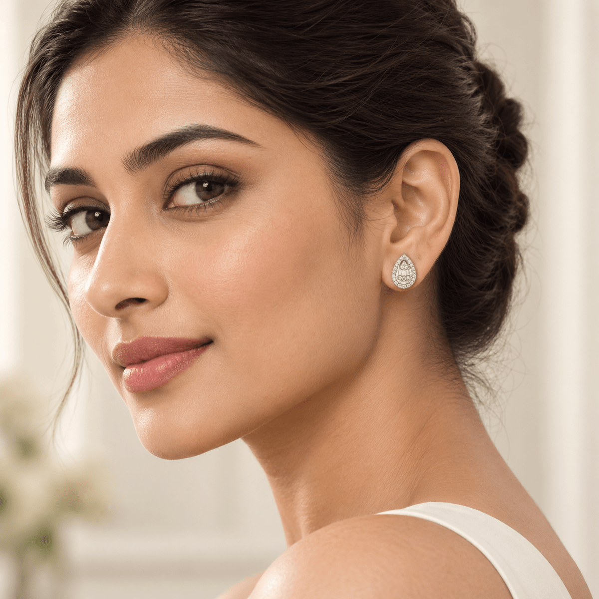 A woman wearing a small 925 Silver Baguette Halo Teardrop Studs by Miraura Jewels