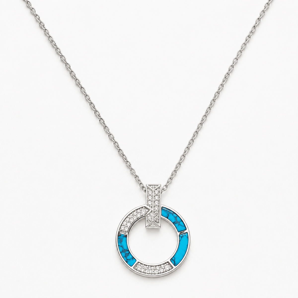 A silver-tone necklace featuring a circular pendant with bright blue inlay and clear pavé accents, 