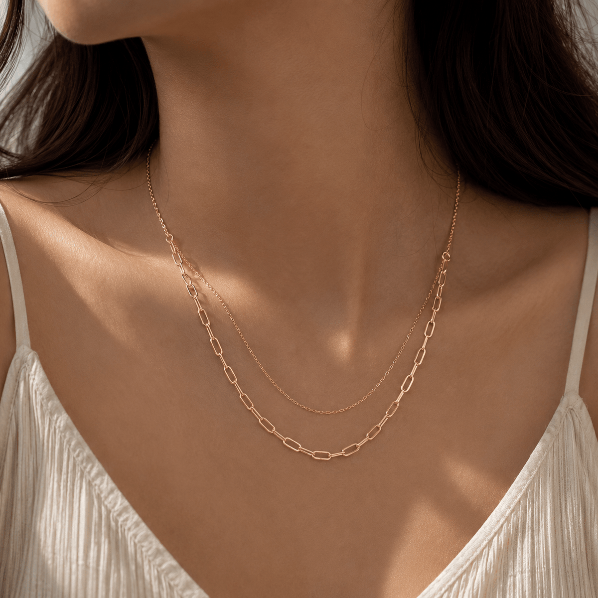 A close-up of a woman's neck and chest wearing a layered rose gold chain, 925 Silver Double-Layered Rose Gold Link Chain