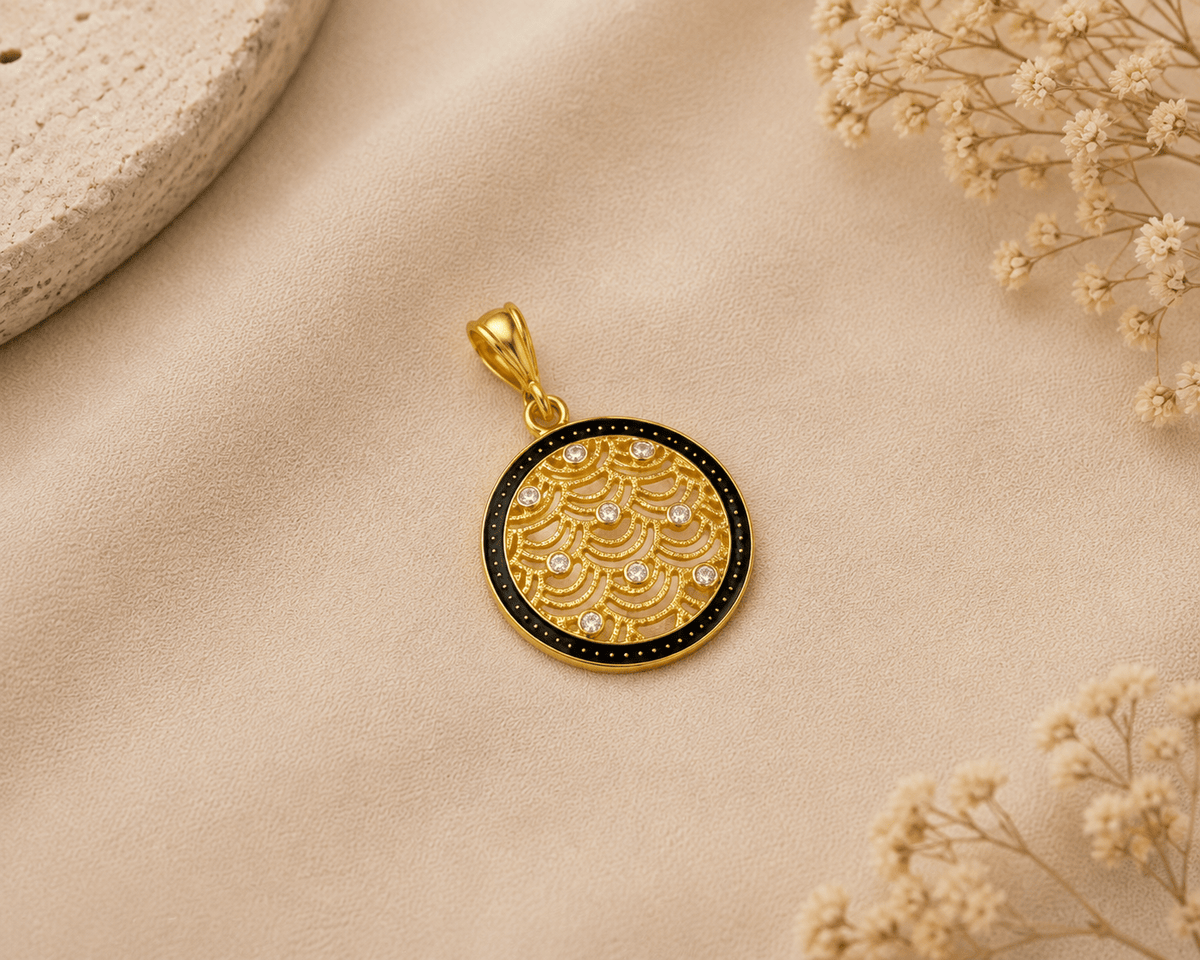 A round gold pendant with a black enamel border and a raised wave pattern accented by small clear stones, Gold Filigree Crystal Charm Pendant