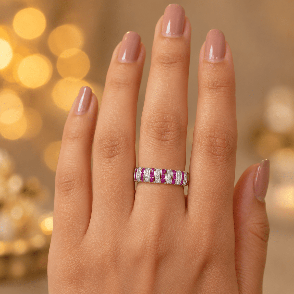 A close-up of a hand wearing a silver band ring with alternating pink and purple textured stripes.