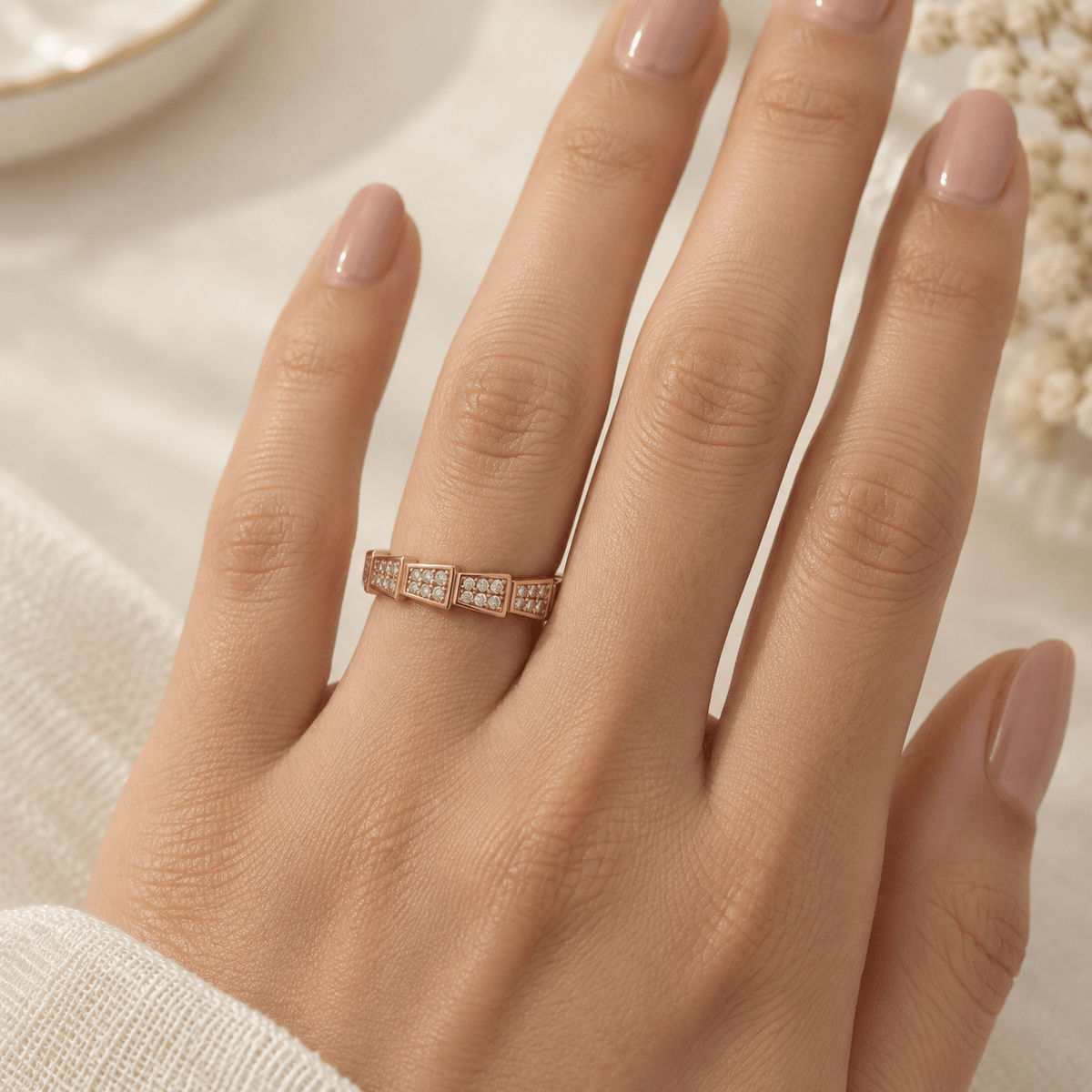 A close-up of a hand wearing a delicate Rose Gold CZ Segment Band | 925 Silver Geometric Pave Ring by Miraura Jewels
