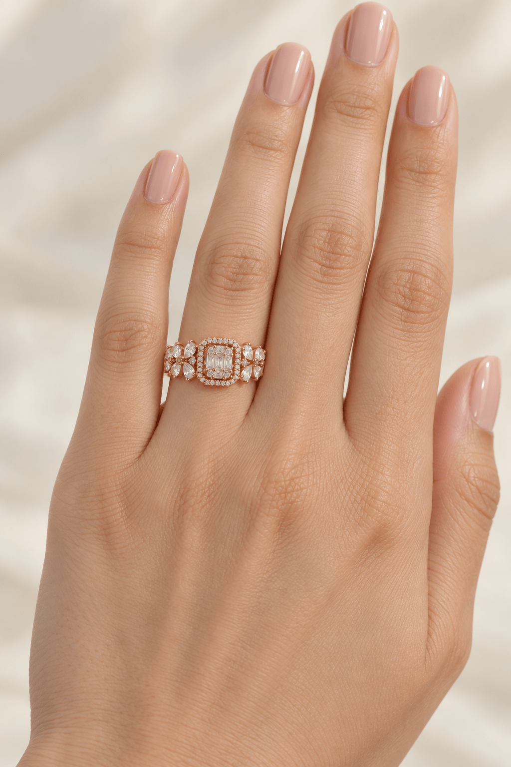 A close-up of a hand wearing a 925 Silver Baguette Halo Ring | Rose Gold Statement Band by Miraura Jewels