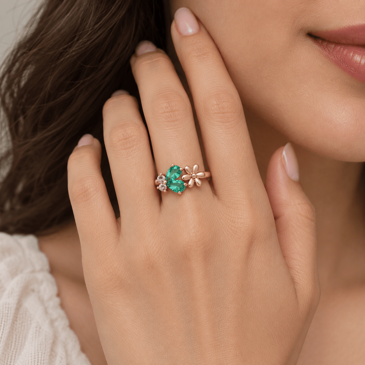 A close-up lifestyle shot of a woman's hand wearing a Rose Gold Green Stone Flower 925 Silver Ring