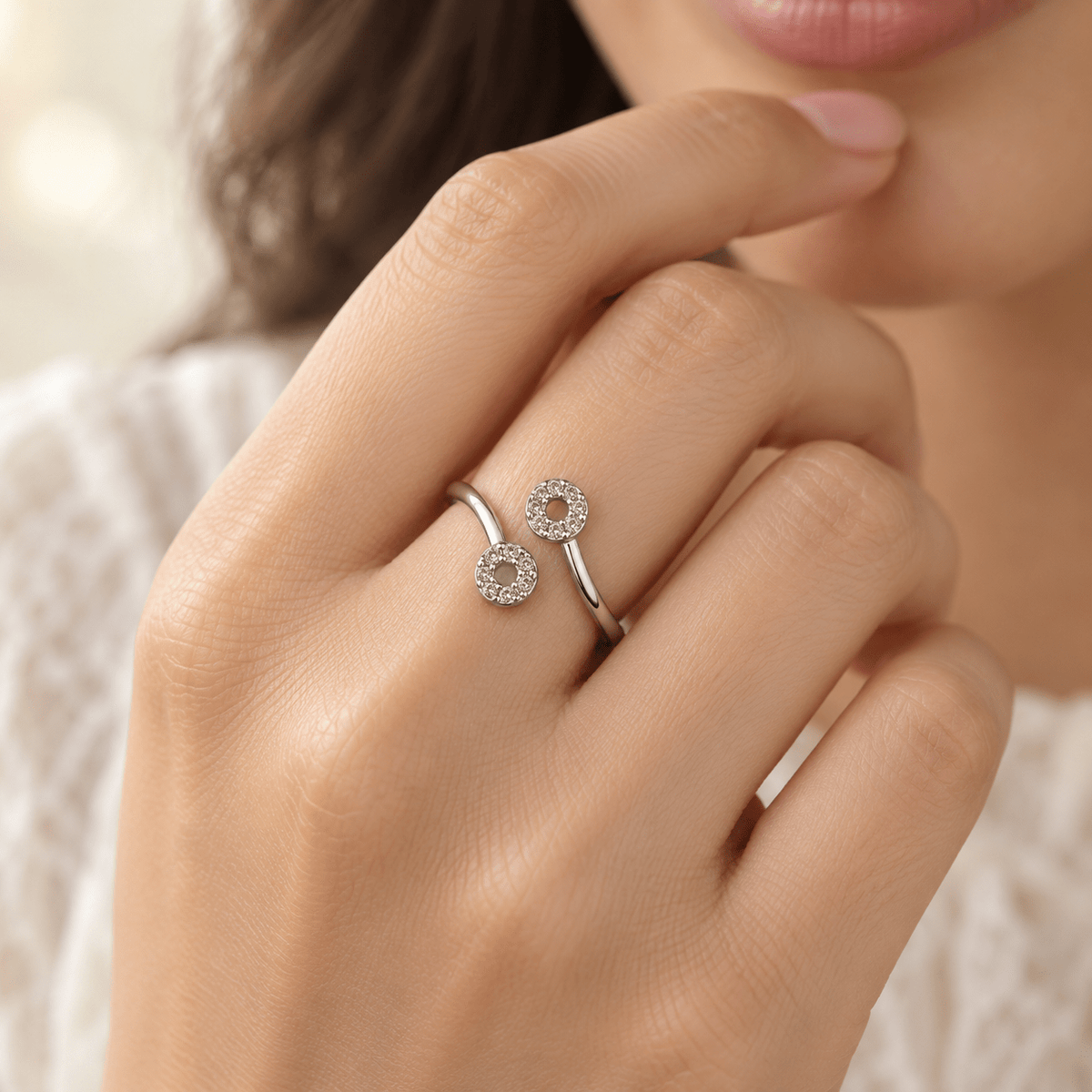 A close-up of a girl's hand wearing a delicate 925 Sterling Silver Minimalist Bypass Ring with CZ Stones by Miraura Jewels