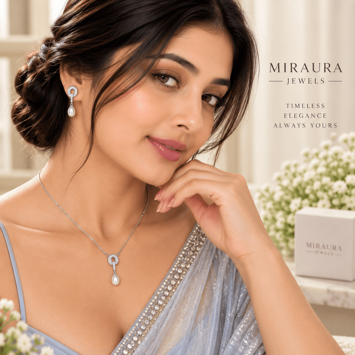 A beautiful young girl wearing a Miraura Jewels 925 silver 3pc necklace set with teardrop baroque pearl pendant and matching baroque drop earrings, styled in a light blue saree. The brand logo and slogan 'TIMELESS ELEGANCE ALWAYS YOURS' are displayed on the right, alongside a branded product box.