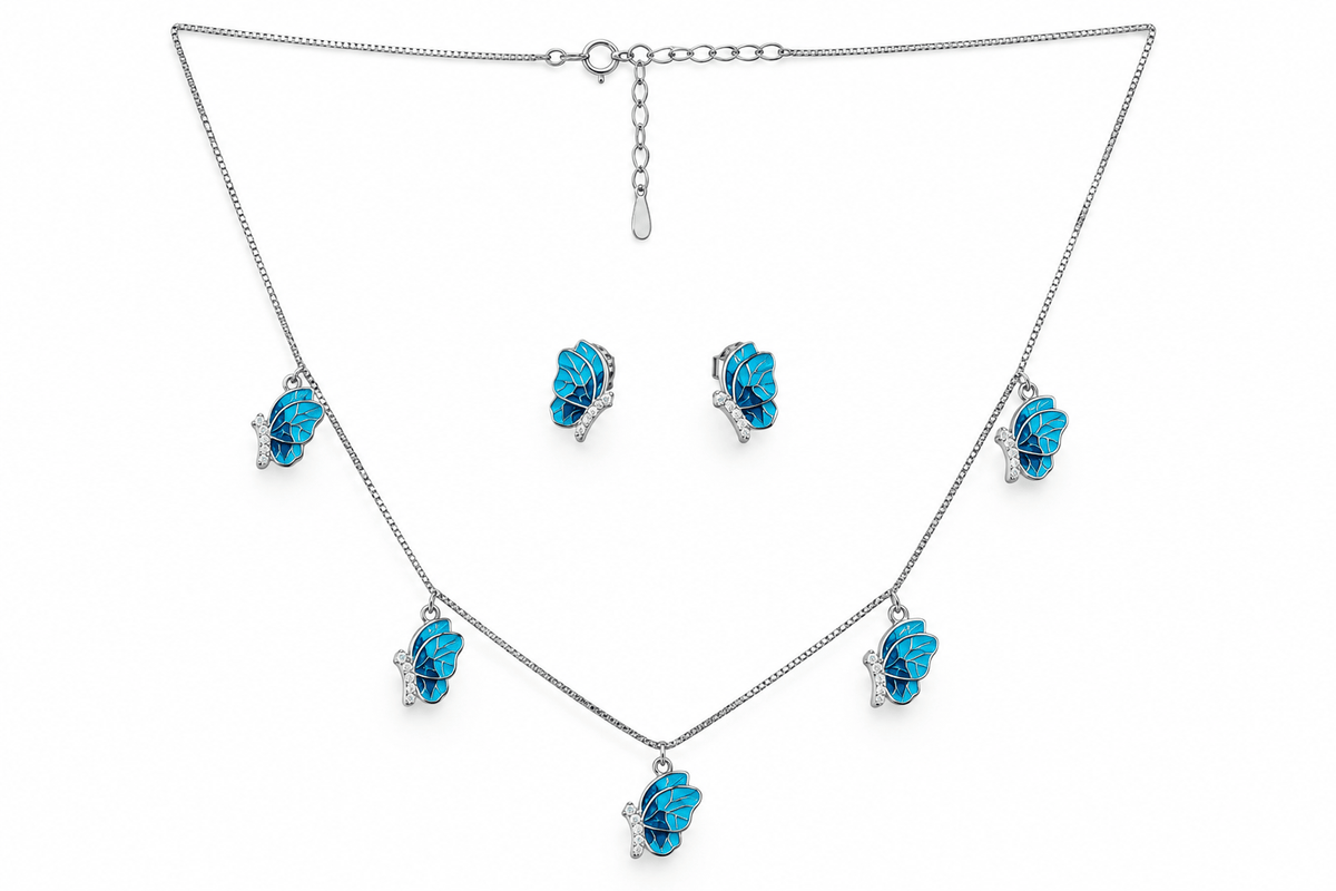 A silver-tone jewelry set featuring a necklace, matching earrings, and a small pendant, each adorned with a bright blue flower-shaped crystal or gemstone in a prong setting, displayed on a clean white background.
