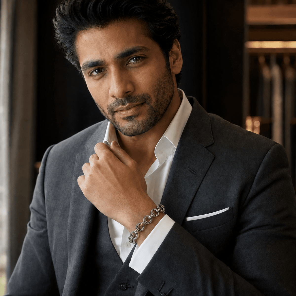 A man in a dark gray suit and white dress shirt wearing a Hammered 925 Silver Textured Rolo Link Bracelet by Miraura Jewels