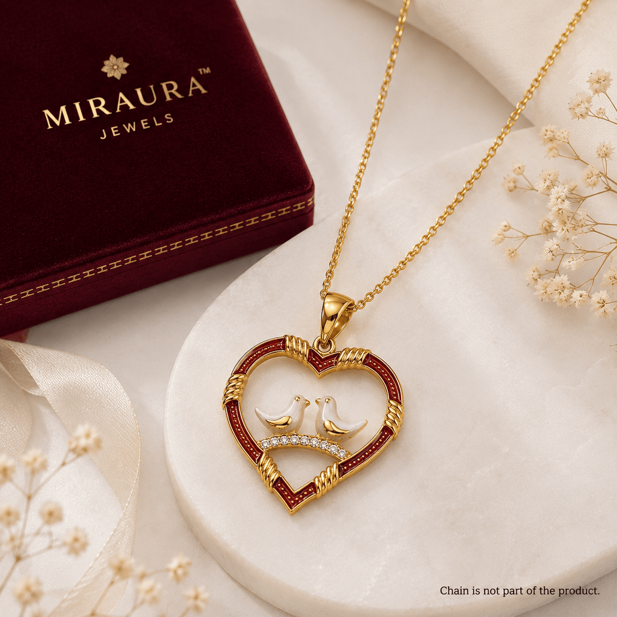 A 925 Silver Love Birds Heart Pendant with red inlay and two white doves in the center, displayed on a white marble surface next to a Miraura Jewels box.